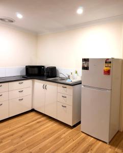 a kitchen with white cabinets and a refrigerator at Fleur de Collie in Collie