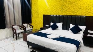a bedroom with a large bed with blue and white pillows at Hotel AJL in Rohtak +13 photos
