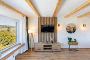 a living room with a table and a large window at Ferienhaus Maarruhe in Schalkenmehren