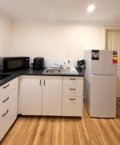 a kitchen with a sink and a refrigerator at Fleur de Collie in Collie