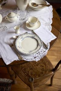 a table with a plate and a tea set on it at B&B Alexandre in Herzele +23 photos