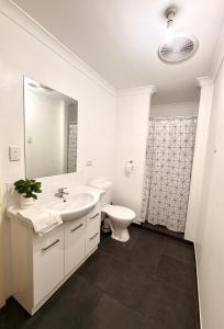 a white bathroom with a sink and a toilet at Fleur de Collie in Collie