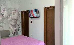 a room with a bed and a tv on a wall at Apartment house Nena in Krk