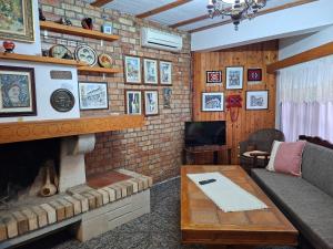 a living room with a brick wall with a fireplace at Vila Mitrojorgji in Shëngjin