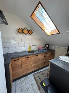 a kitchen with a sink and a skylight at Spessartblick in Heimbuchenthal