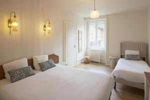 a bedroom with two beds and a window at Logis Hostellerie la Chaumière in Arsonval +52 photos