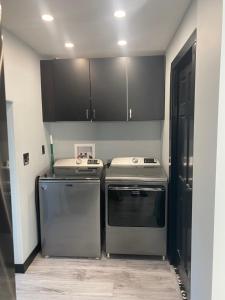 a kitchen with stainless steel appliances and black cabinets at The Station House in Brantford