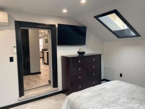a bedroom with a mirror and a dresser and a television at The Station House in Brantford