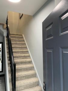 a hallway with stairs with a blue door at The Station House in Brantford +3 photos