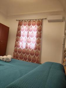 a bedroom with a bed and a window with a curtain at Appartamento Giulia in Favignana
