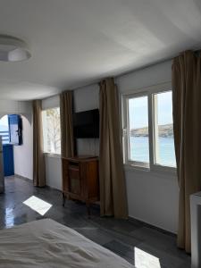 a bedroom with a bed and a tv and windows at Saint Nectaire in Kardhianí