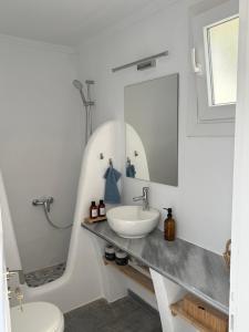 a white bathroom with a sink and a mirror at Saint Nectaire in Kardhianí +20 photos