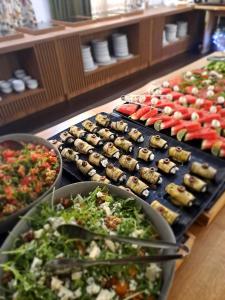 a buffet line of sushi and vegetables on trays at Park Hotel Fairy in Chiflik
