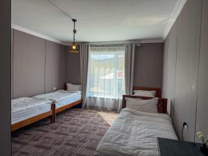 two beds in a small room with a window at Healing stay hostel in Dzuunmod