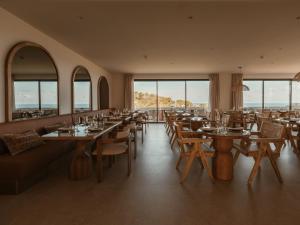 a restaurant with tables and chairs and windows at Besai Ibiza Boutique Hotel - New Opening in San Jose