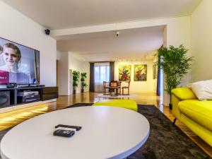 a living room with a yellow couch and a white table at Dunajec Mansion in Czchów +20 photos