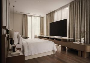 a bedroom with a large bed and a television at FairMounts Plaza Inns Near Delhi International Airport in New Delhi