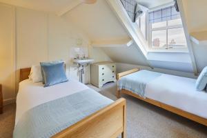 a attic bedroom with two beds and a sink at Sandy Toes in Sandsend