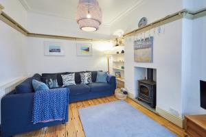 a living room with a blue couch and a fireplace at Sandy Toes in Sandsend