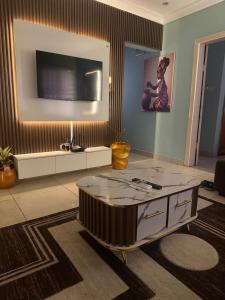 a living room with a tv and a coffee table at Ivory Max in Ikeja +16 photos
