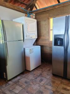 a kitchen with a refrigerator and a washer and dryer at Jimmys cabins in La Periquera +13 photos