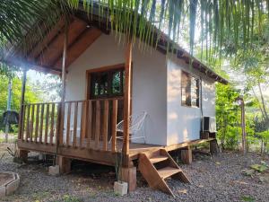 a tiny house with a porch and a staircase at Jimmys cabins in La Periquera