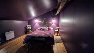 a purple bedroom with a bed with a purple wall at La demeure de vos désirs in Pressac