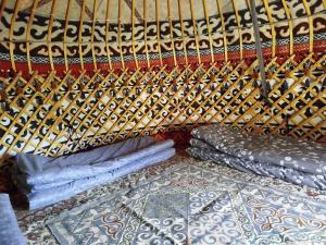 a room with a bed and pillows in a room at Kyrgyz Yurt Camp in Mineralʼnyy Istochnik Altyn-Arasan