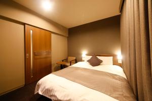 a bedroom with a bed with two lights on at Dormy Inn Toyama Natural Hot Spring in Toyama +61 photos