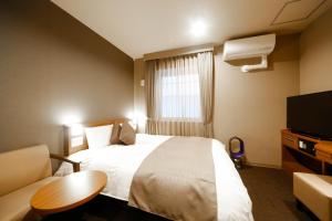 A bed or beds in a room at Dormy Inn Toyama Natural Hot Spring