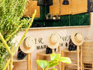 a group of straw hats sitting on chairs in front of a store at Riad Dar Najwa in Marrakesh