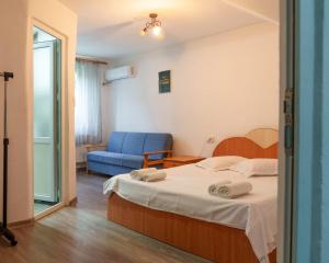 a bedroom with a bed and a blue chair at CasaMarinela in Orşova +27 photos