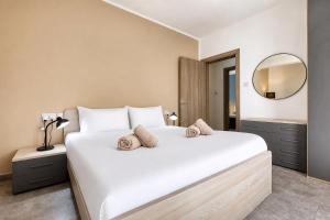 a bedroom with a large white bed and a mirror at Spacious and refined 3 bedroom duplex KARP1-1 in San Ġwann