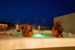 two women in a bathtub with a dog in it at Drumcarrow Luxury Lodges in St. Andrews
