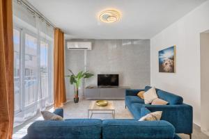 a living room with two blue couches and a tv at Spacious and refined 3 bedroom duplex KARP1-1 in San Ġwann