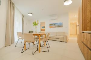 a dining room with a table and chairs and a couch at Vista Point Suites in Marsalforn