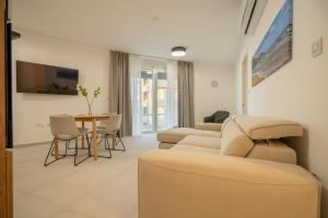 a living room with a couch and a table at Vista Point Suites in Marsalforn