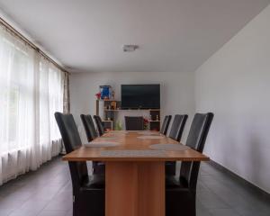 a dining room with a wooden table and black chairs at CasaMarinela in Orşova