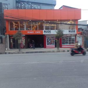 a person riding a scooter in front of a store at Peace Hostel in Kathmandu