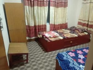 a small bedroom with a bed and a chair at Peace Hostel in Kathmandu
