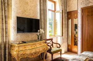 a living room with a table and a tv on a wall at The Moonlight Luxury Hotel in Baku