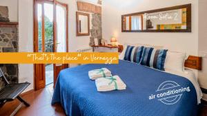 a bedroom with a blue bed with towels on it at Camere Giuliano basso in Vernazza