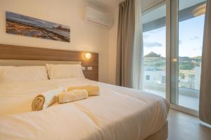a bedroom with a white bed with towels on it at Vista Point Suites in Marsalforn