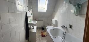a bathroom with a sink and a tub and a toilet at Ferienwohnung Sauerländer in Plettenberg +16 photos