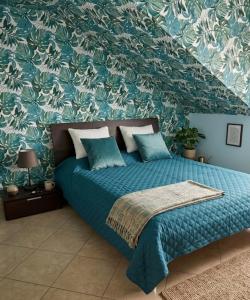 a bedroom with a bed with a blue comforter at Azzurro Garda in Sirmione