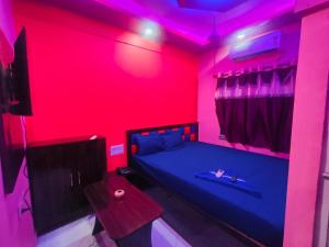 a bedroom with a blue bed and a red ceiling at Hotel Happy House in kolkata
