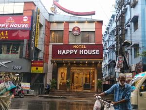 a man riding a bike in front of a happy house at Hotel Happy House in kolkata
