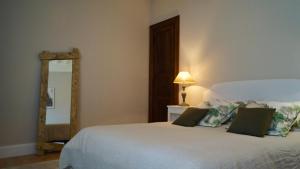 a bedroom with a white bed and a mirror at Maison Thoumieu in Azereix +25 photos