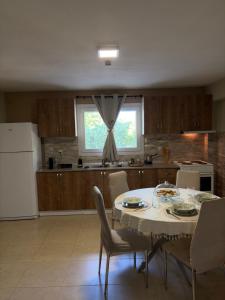 a kitchen with a table and chairs and a white refrigerator at Filemial House in Agios Mamas