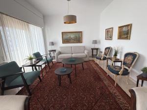 ein Wohnzimmer mit Sofa, Tischen und Stühlen in der Unterkunft Ellados in Strovolos + 32 Fotos